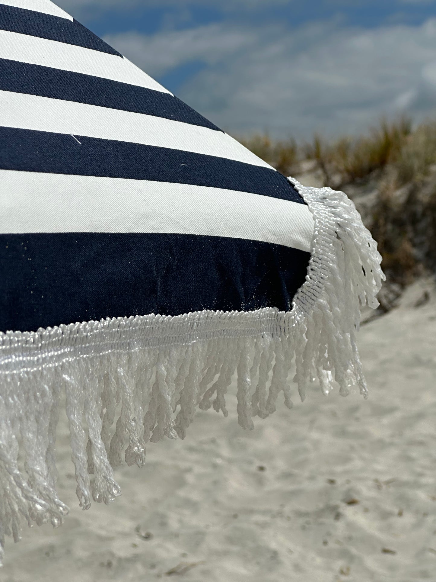 Hollie & Harrie Classic Fringe 210cm Canvas Beach Umbrella - Hello SaiWow the Hello Sailor is a Classic.
The Fringe 210cm Beach Umbrella is a classic beach lovers staple. The thick & luxurious 100% cotton canopy with a retro fringBeachkit