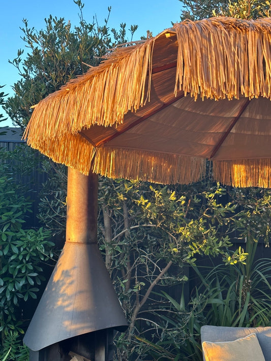 Hula 275cm Market Umbrella with raffia thatch canopy and crank lift system in outdoor garden setting