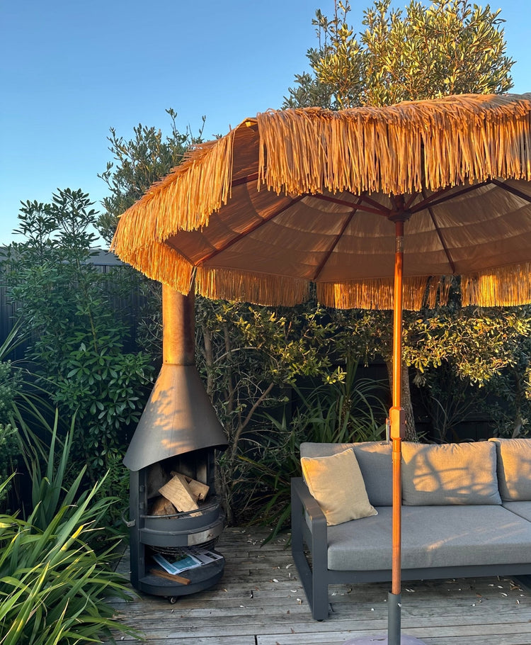 Hula 275cm Market Umbrella with raffia thatch canopy and crank lift in outdoor patio setting