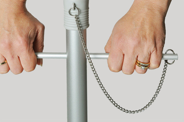 Close-up of hands using the twist anchoring system on the Daytripper 210cm Beach Umbrella pole with chain detail.