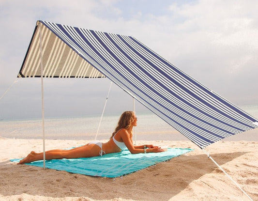 Lovin Summer Sombrilla shade tent with blue and white stripes on sandy beach