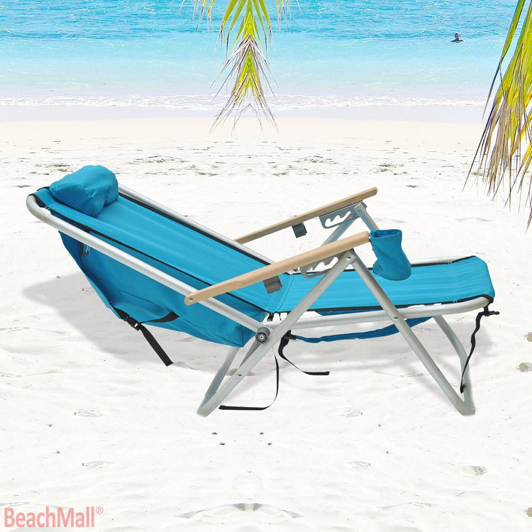 Beachkit Wearever Backpack Chair in turquoise on sandy beach with palm leaves and ocean background