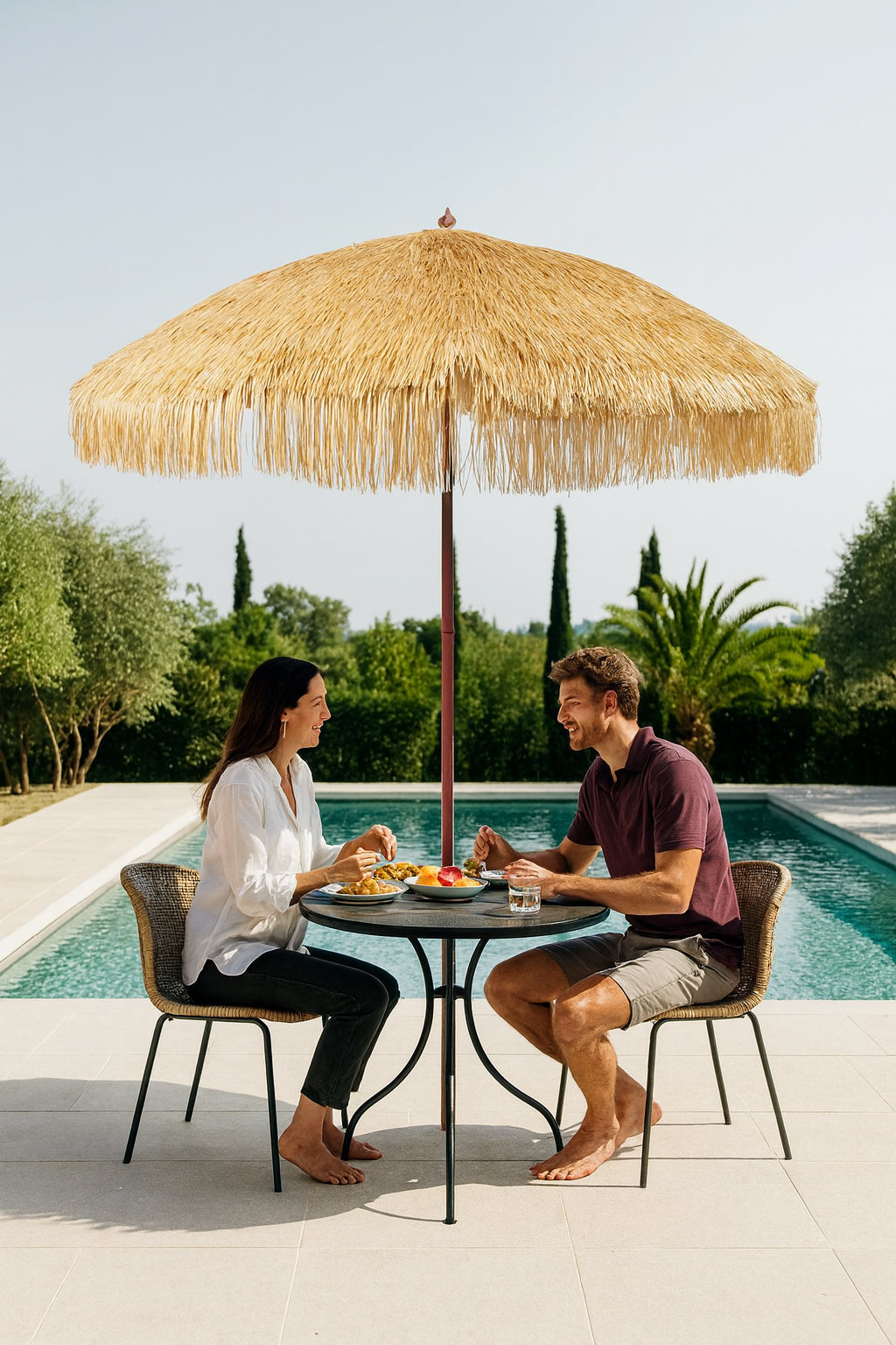 Hula 240cm raffia thatch market umbrella providing UPF 50+ shade over outdoor dining by the pool