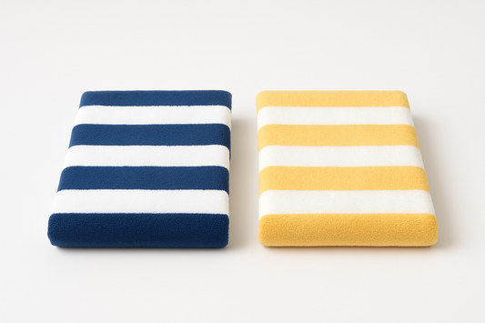 An image with Navy white striped towel and yellow and white striped towel folded on white background