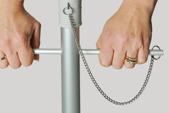 Close-up of hands using the twist anchoring system on the Daytripper 210cm Beach Umbrella pole with chain detail.